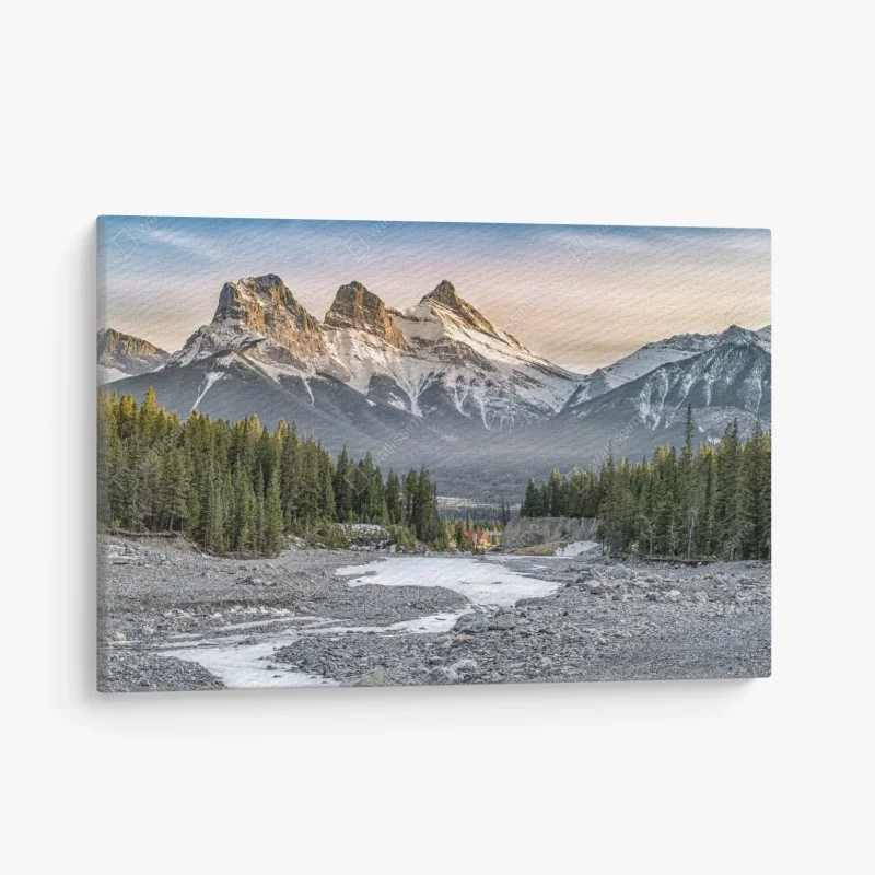 Quadro su tela tramonto sulle cime innevate con foresta e ruscello