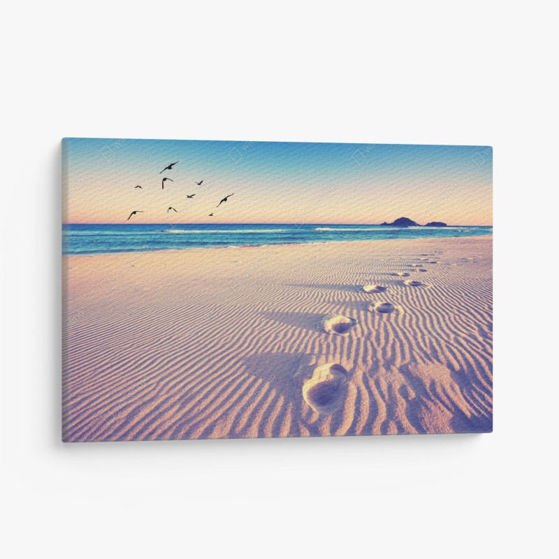 Quadro su tela impronte magiche sulla spiaggia al tramonto