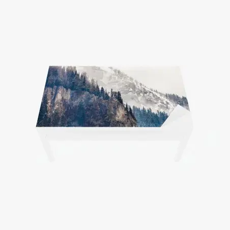 Adesivo per tavolo e scrivania paesaggio montano: scogliera innevata e boschi di conifere • Wallissimo®