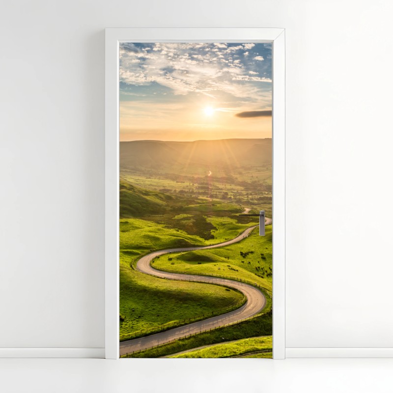 Adesivo per porta strada serpeggiante al tramonto sulle colline verdi