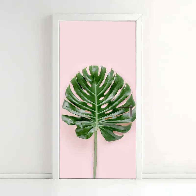 Adesivo per porta foglia di monstera su sfondo rosa pastello