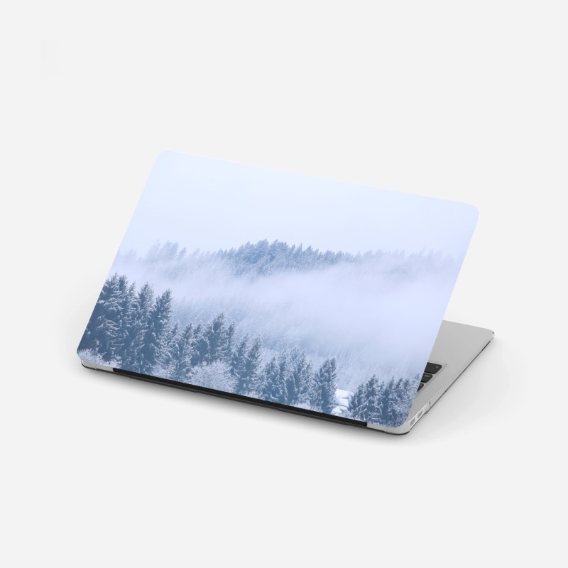 Adesivo per laptop nebbia sulla foresta di conifere innevata