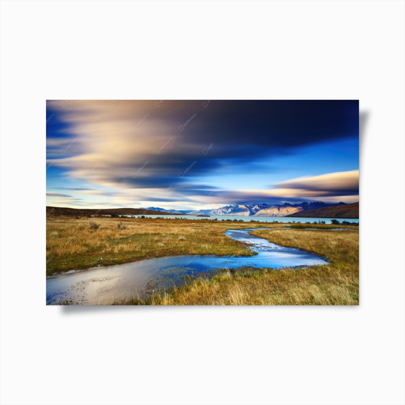 Poster paesaggio montano con ruscello serpeggiante e cielo drammatico