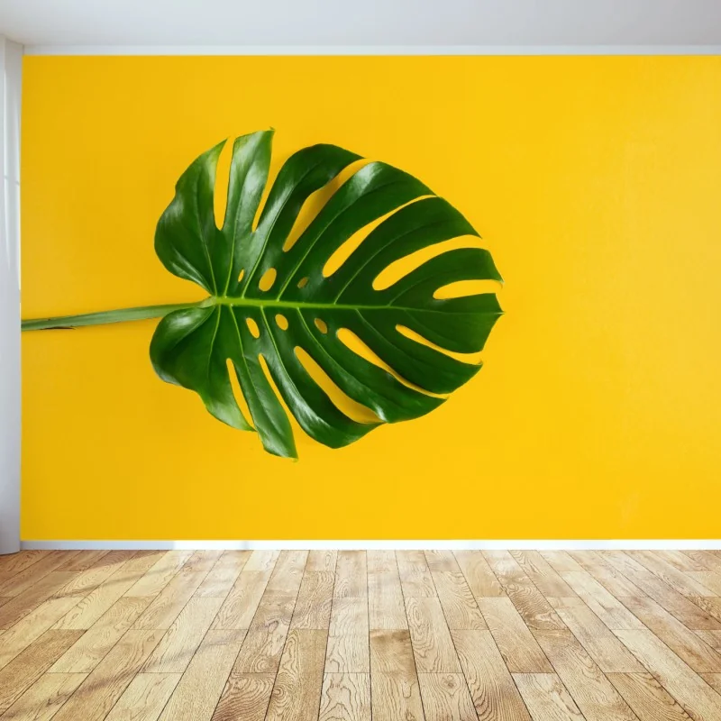 Carta da parati foglia di monstera su sfondo giallo vibrante