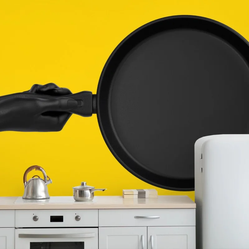 Carta da parati contrasto culinario: padella nera su sfondo giallo